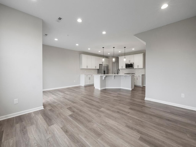 unfurnished living room with sink and light wood-type flooring