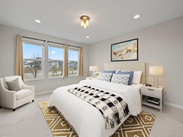 bedroom with a textured ceiling and light colored carpet