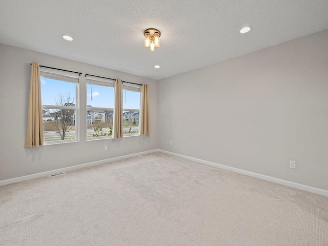 empty room featuring carpet and a textured ceiling