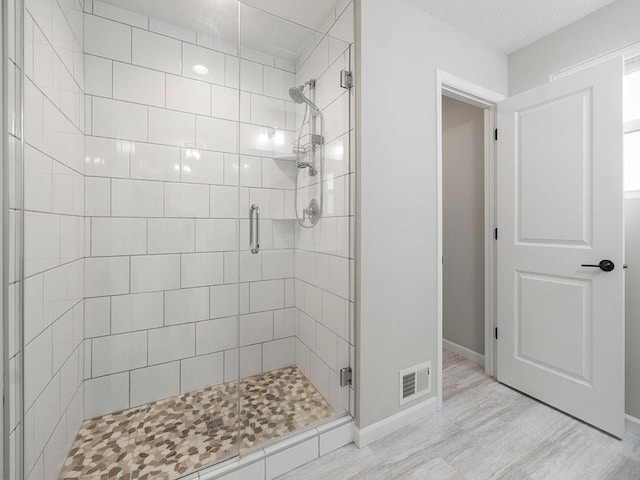 bathroom with hardwood / wood-style flooring and walk in shower