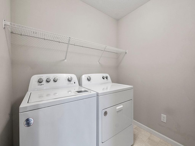 washroom featuring a textured ceiling and washing machine and clothes dryer