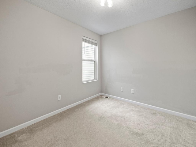 empty room with carpet and a textured ceiling