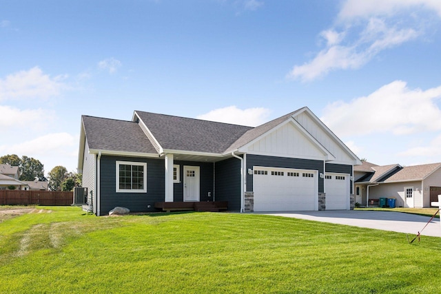 view of front of home with central AC unit, a garage, and a front lawn