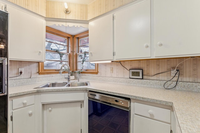 kitchen with black dishwasher, sink, and white cabinets