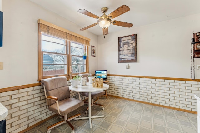 interior space featuring brick wall and ceiling fan