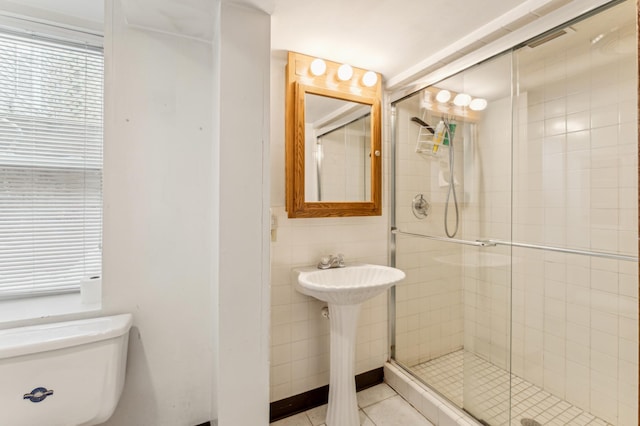 bathroom with sink, tile walls, tile patterned flooring, walk in shower, and toilet