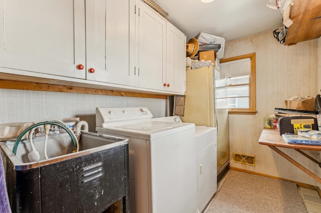 laundry room with cabinets, washer and clothes dryer, and sink