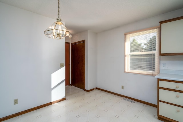 unfurnished dining area featuring an inviting chandelier