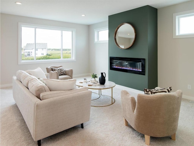 living room with baseboards, recessed lighting, light colored carpet, and a glass covered fireplace