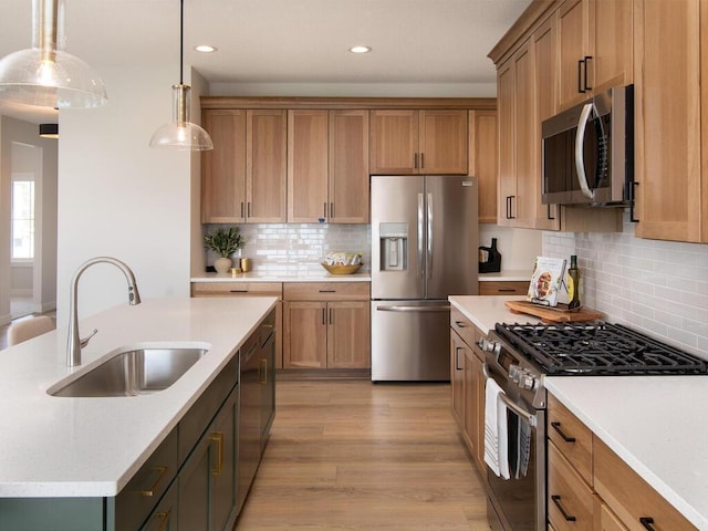 kitchen featuring recessed lighting, a sink, stainless steel appliances, decorative light fixtures, and backsplash