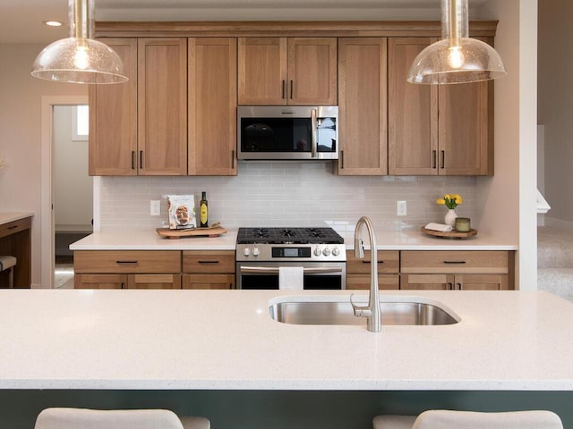 kitchen featuring brown cabinetry, a sink, stainless steel appliances, and decorative backsplash