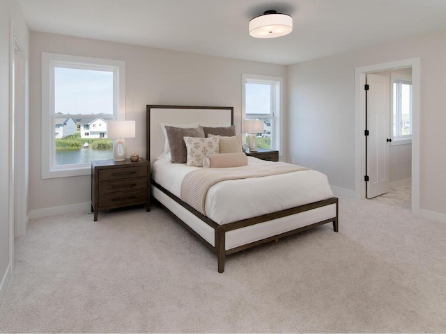 bedroom with baseboards and light carpet