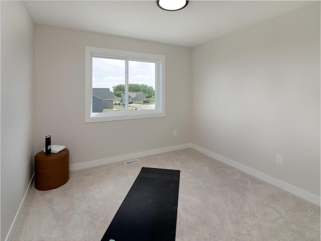 exercise room featuring baseboards, visible vents, and carpet flooring