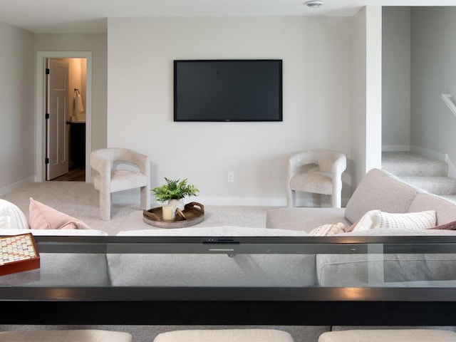 carpeted living area with stairway and baseboards