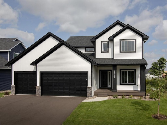 view of front of home featuring covered porch, a shingled roof, driveway, a front yard, and an attached garage