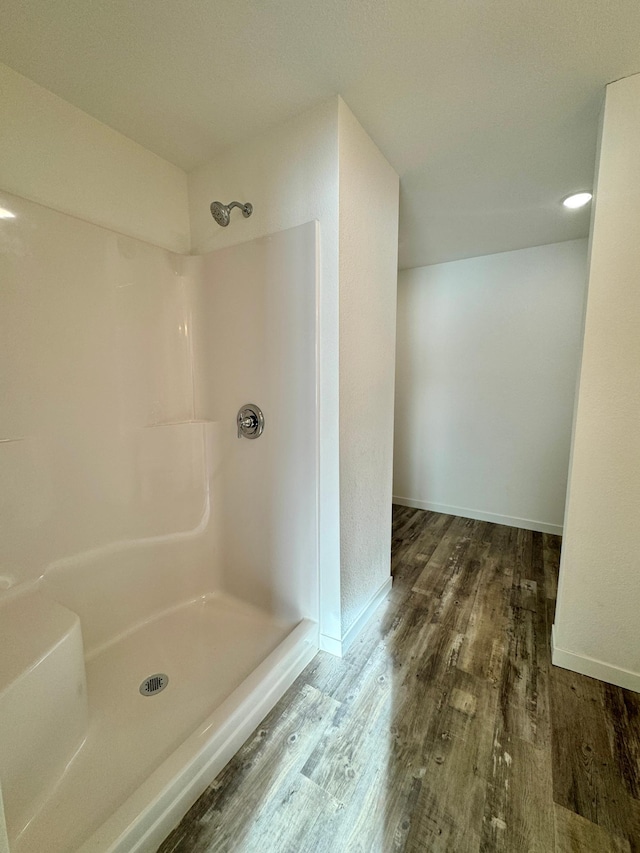 bathroom with hardwood / wood-style flooring and walk in shower