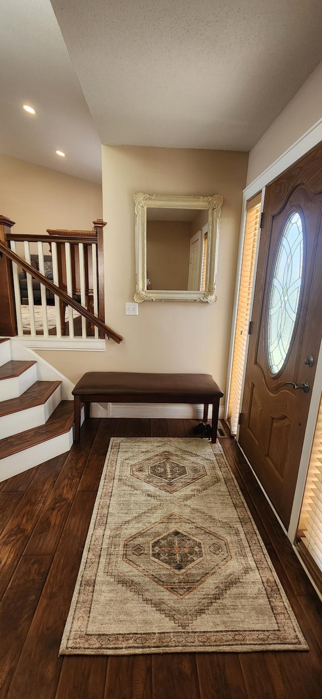 foyer featuring a textured ceiling and dark wood-type flooring