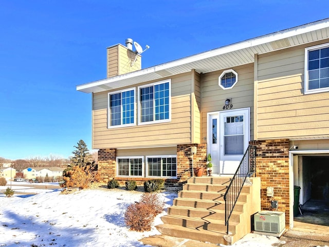 snow covered property entrance featuring a garage