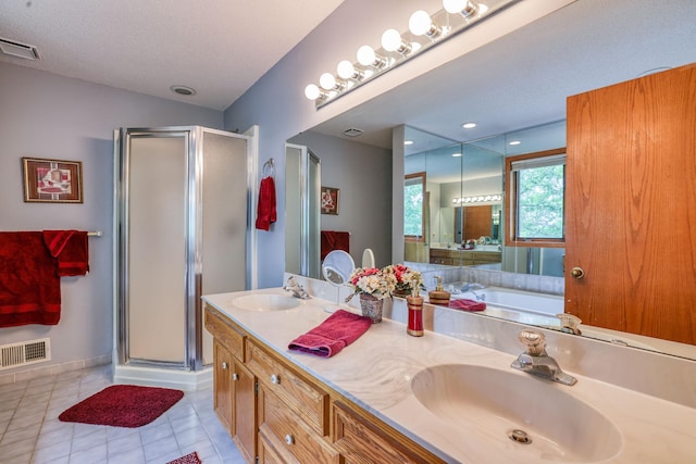 bathroom featuring a shower with door, a textured ceiling, tile patterned flooring, and vanity