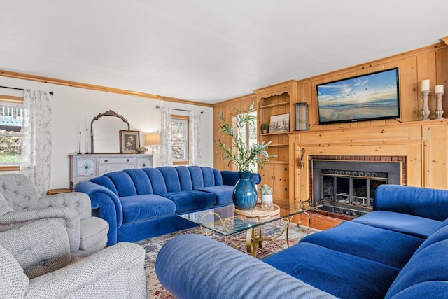 living area with crown molding, plenty of natural light, wood walls, and a fireplace