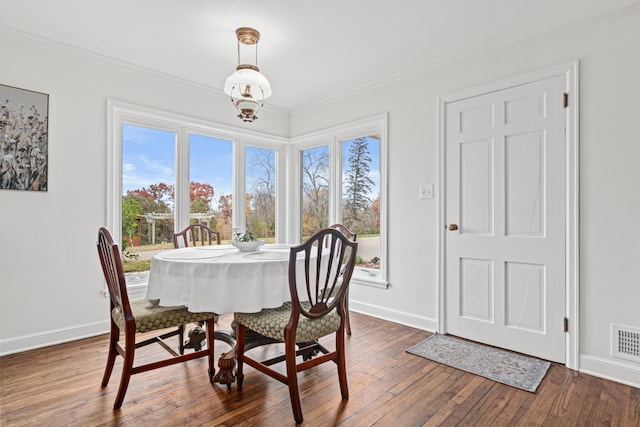 dining space with crown molding, baseboards, visible vents, and dark wood finished floors