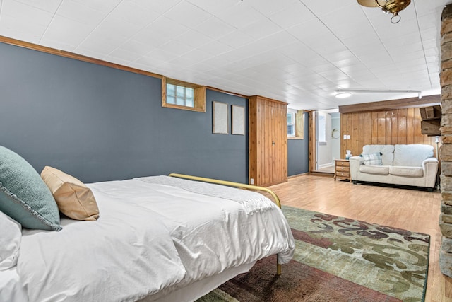 bedroom with wood finished floors and ornamental molding