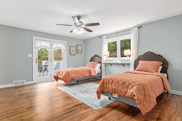 bedroom featuring wood finished floors, a ceiling fan, visible vents, baseboards, and access to outside