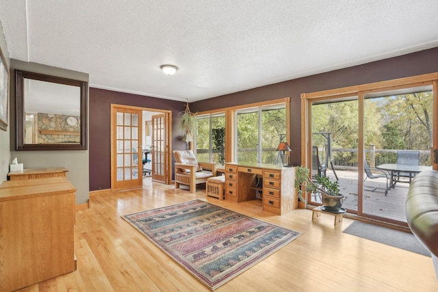 interior space with french doors, a textured ceiling, and light hardwood / wood-style floors