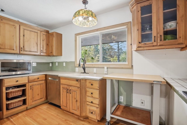 kitchen with sink, hanging light fixtures, and light wood-type flooring