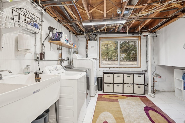 laundry area featuring electric panel, independent washer and dryer, sink, and light tile patterned floors