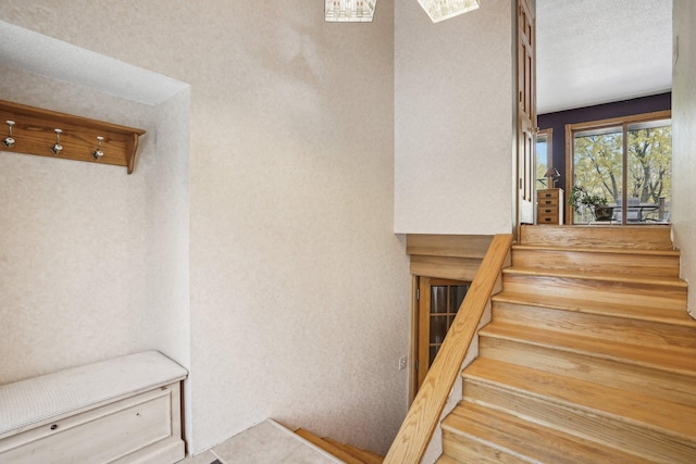 stairs featuring a textured ceiling