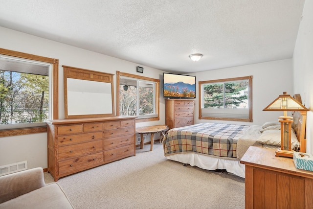 carpeted bedroom featuring a textured ceiling