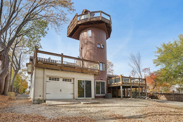 back of property with a balcony, central AC unit, and a garage