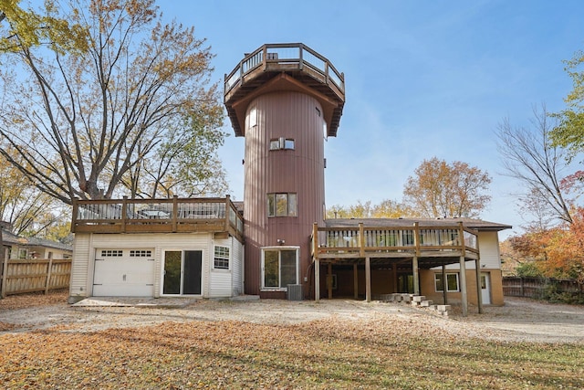 back of property featuring a garage, a deck, and central air condition unit