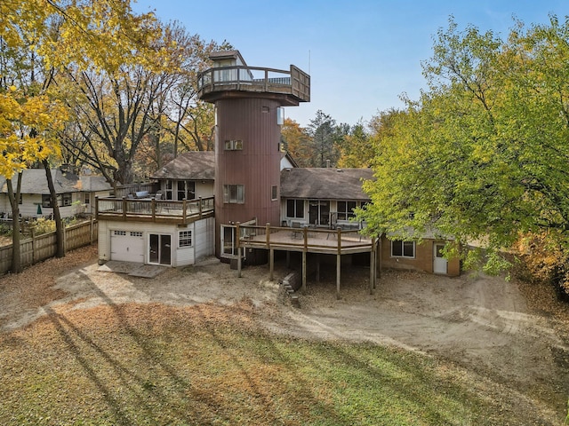 back of property featuring a garage and a wooden deck