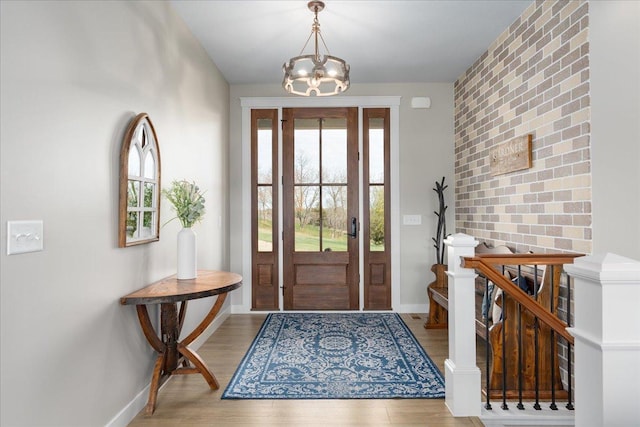 entryway with wood-type flooring, a wealth of natural light, and a chandelier