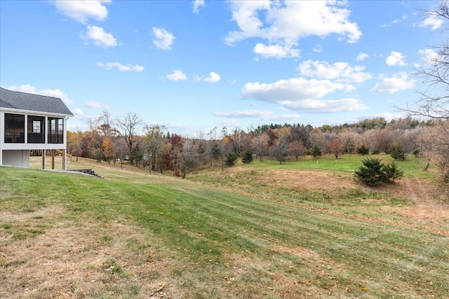 view of yard with a sunroom and a rural view