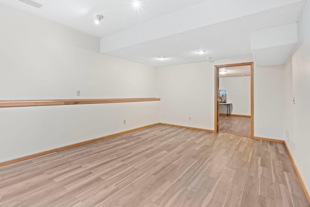 empty room with baseboards, visible vents, and light wood-type flooring