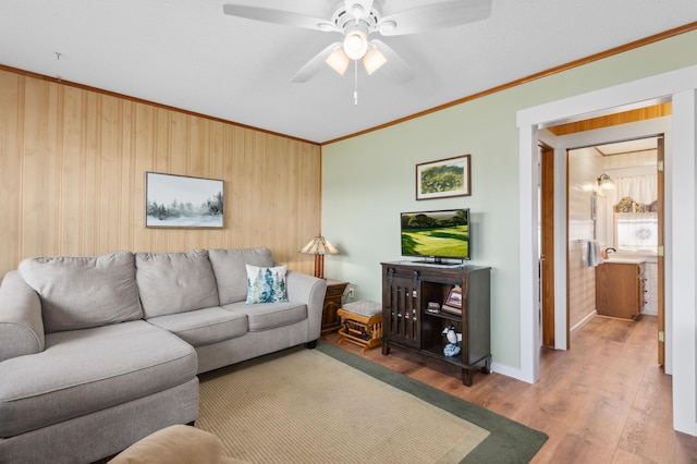 37760 310th St, Aitkin, MN 56431 - living area featuring crown molding, wood walls, wood finished floors, a ceiling fan, and baseboards