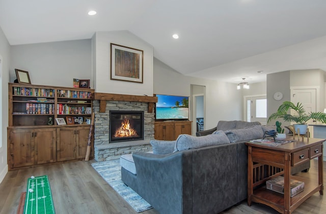 living room with light wood-type flooring, lofted ceiling, and a fireplace