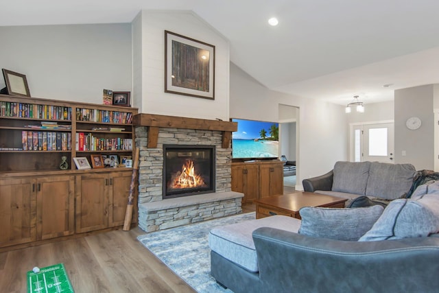 living room featuring light wood-type flooring, lofted ceiling, and a fireplace