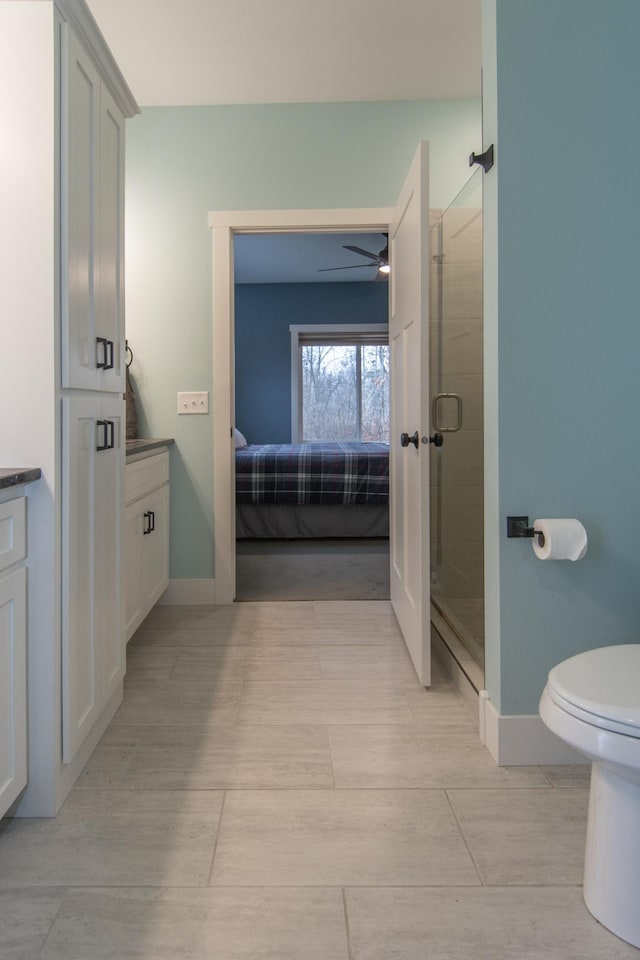 bathroom featuring toilet, an enclosed shower, vanity, and ceiling fan