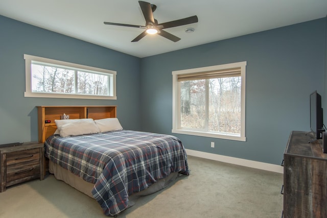 carpeted bedroom featuring multiple windows and ceiling fan