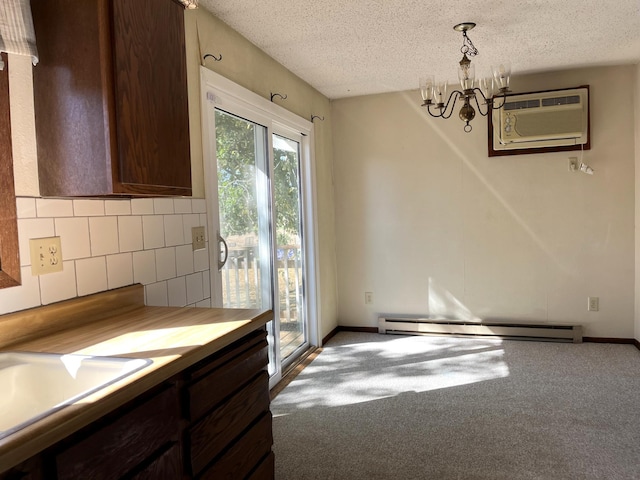 unfurnished dining area with a wall unit AC, baseboard heating, carpet, an inviting chandelier, and a textured ceiling