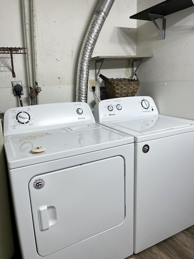 washroom with dark wood-type flooring and separate washer and dryer