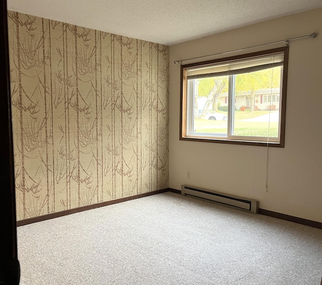 carpeted empty room featuring a textured ceiling and baseboard heating