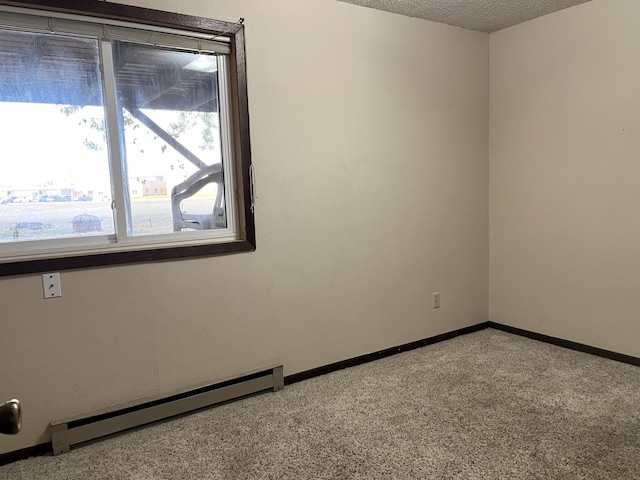 carpeted spare room with a textured ceiling and a baseboard radiator