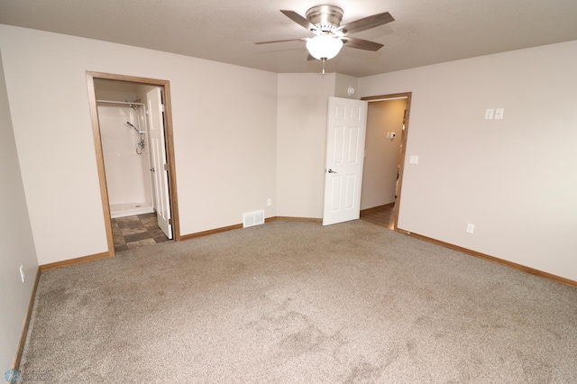 unfurnished bedroom featuring a walk in closet, carpet floors, and ceiling fan