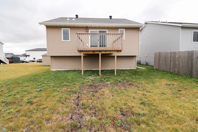 rear view of property featuring a wooden deck and a yard