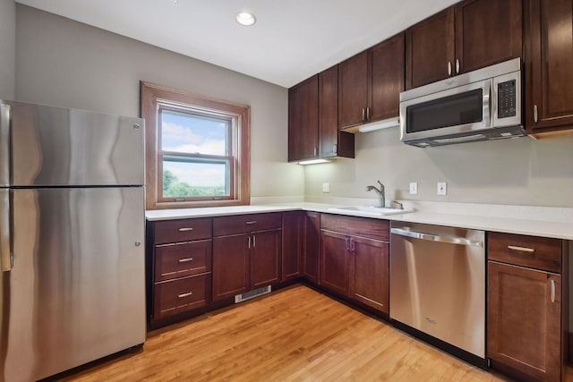 kitchen with sink, light hardwood / wood-style flooring, and stainless steel appliances